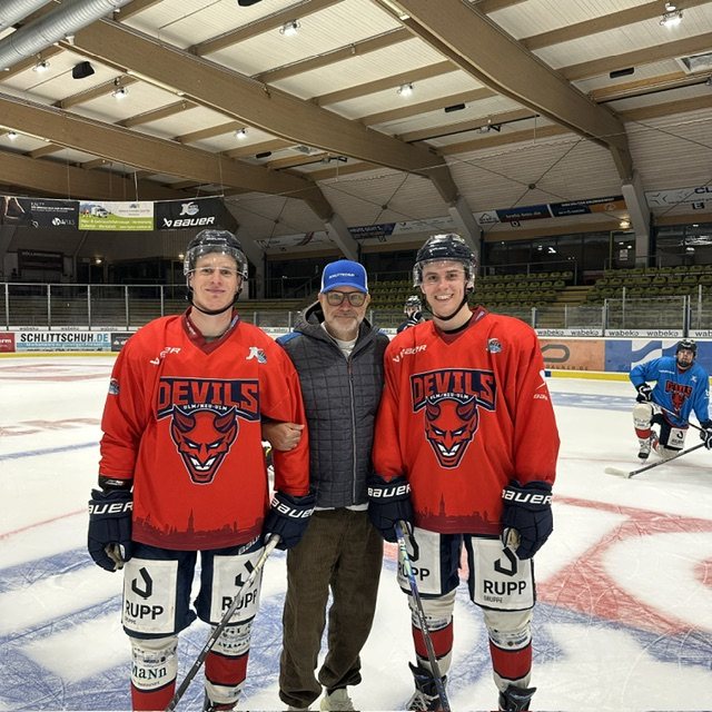 Alexander Böhmler mit Spielern der Devils Ulm/Neu-Ulm auf dem Eis